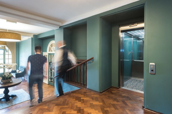 Lift with jade green gloss perspex panels and carpeted floors at King Edward V11 private housing project