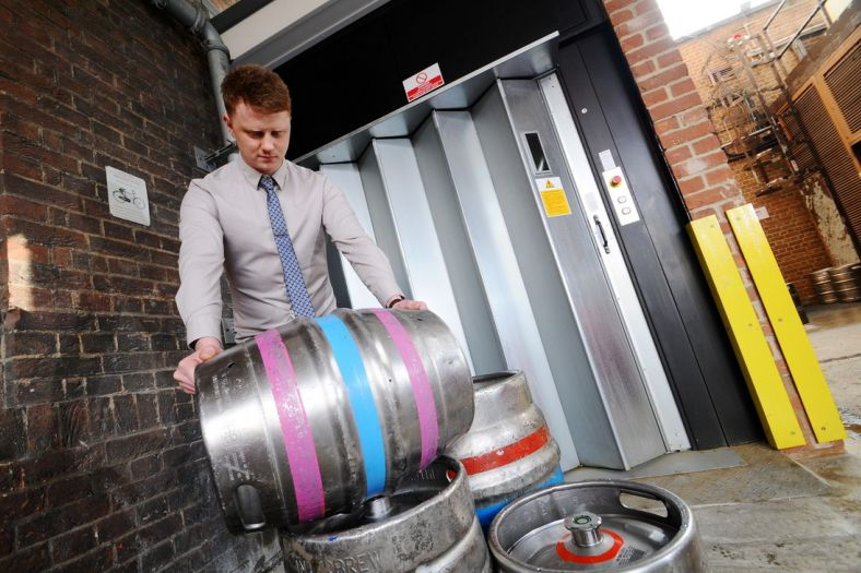 A goods lift moving beer barrels to a mezzanine floor in a national pub chain
